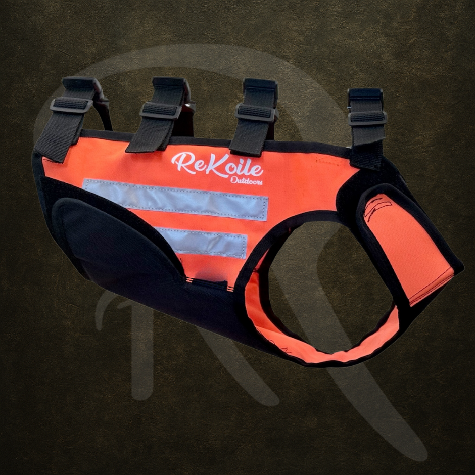 Orange dog cut resistant vest/harness with black straps on a dark background