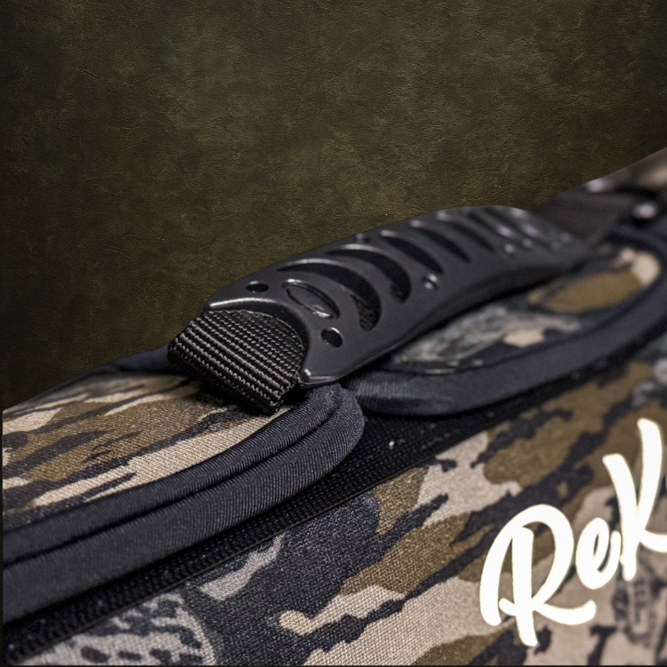 Camouflage dog vest with a easy to grab handle and 'Rekoile' branding on a dark background